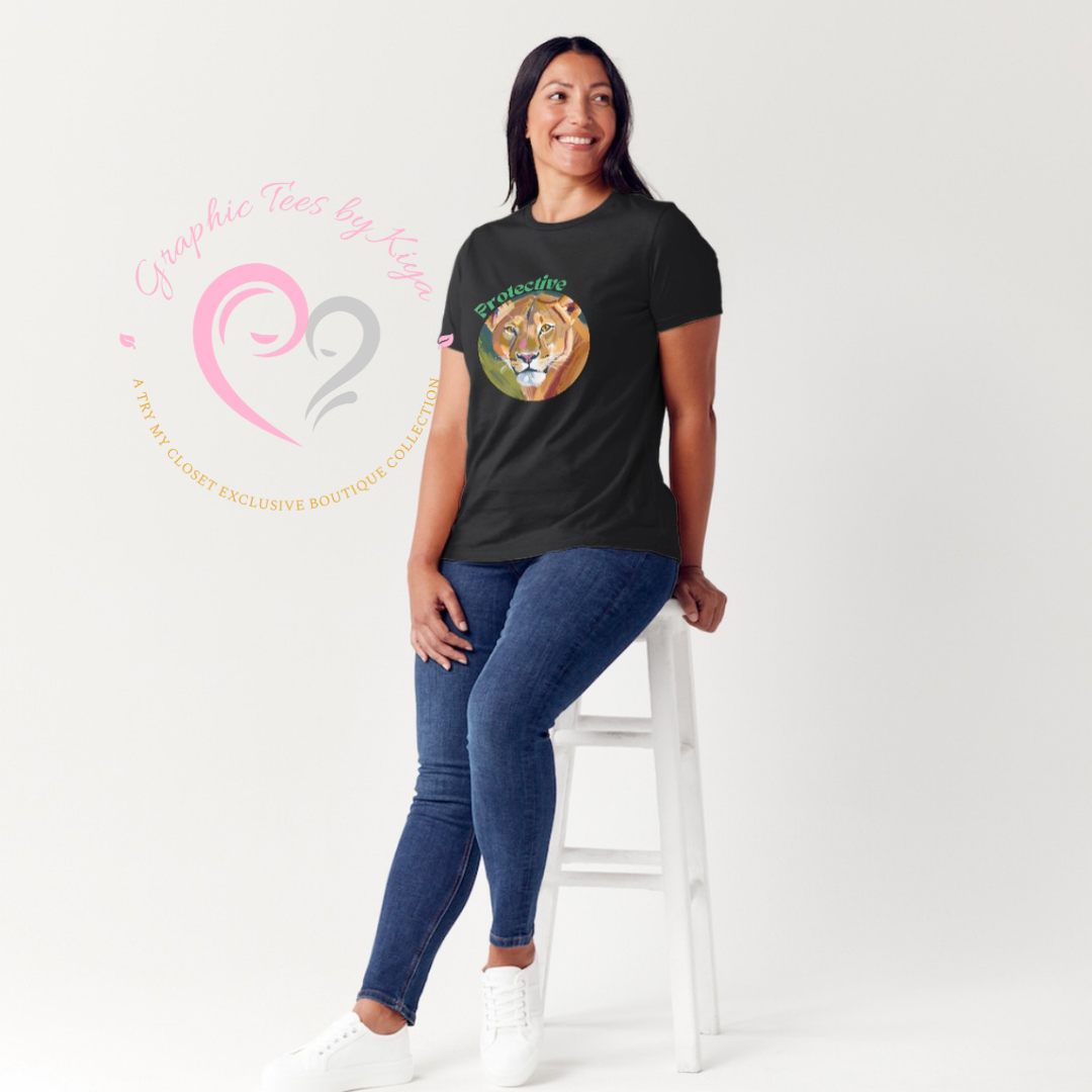 A woman in a black Protective Graphic Tee from Try My Closet, featuring “Queenality,” sits on a white stool and smiles, with the Try My Closet logo visible. Custom orders are available for this protective graphic tee.