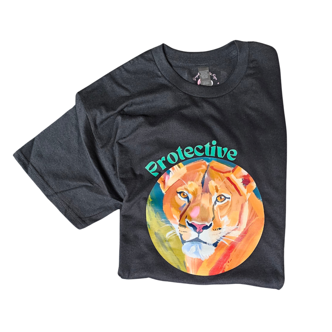 The Protective Graphic Tee by Try My Closet showcases a colorful painted lioness face in a circle with Protective in teal above. This unique black shirt is available for custom orders.