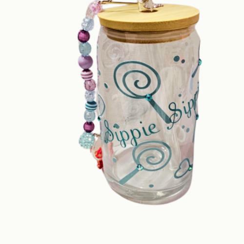 The Try My Closet Sippie Sippie Lollipop Candy Color Changing Glass Tumbler features a clear glass body, wooden lid, beaded handle, blue lollipop art, and Dippie Sippie text—perfect for cold drinks or as a unique party trick.
