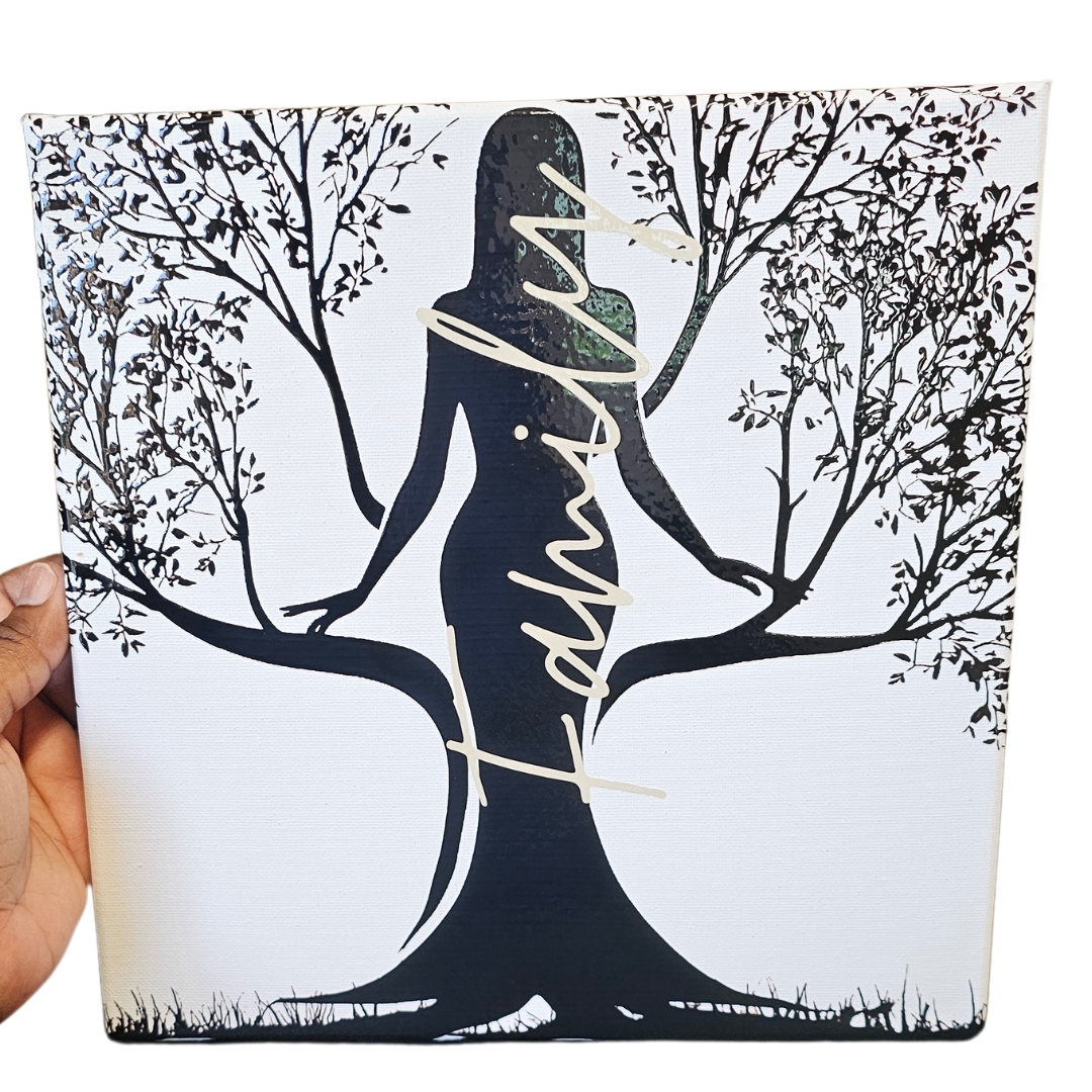 A hand holds the Try My Closet Rooted Family Canvas 10x10, featuring a woman’s silhouette as a tree with Family in script—an artistic home décor piece that celebrates your family story.