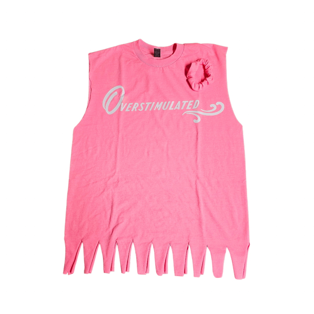 The Try My Closet Retro Style Overstimulated Graphic Tee in hot pink features a bold white graphic, jagged edges, a swirl accent, and playful ruffle, plus comes with a free matching scrunchie. Limited edition—perfect for retro tee lovers!.