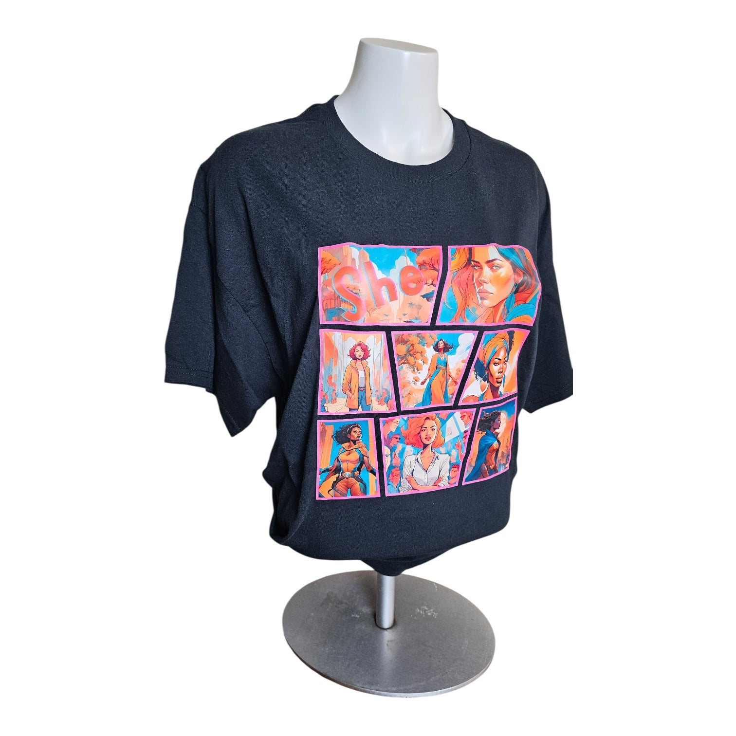 The She Comic Graphic Tee Limited Edition by Try My Closet is displayed on a mannequin, featuring nine vibrant comic-style panels with diverse illustrated characters in pink, blue, and orange for a standout look.