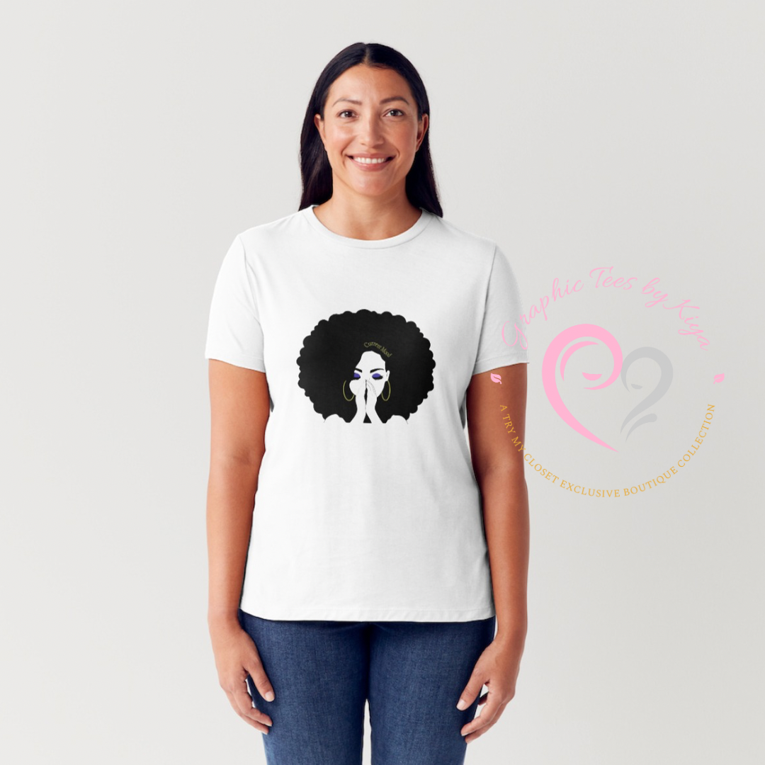A woman smiles in a trendy Try My Closet Current Mood Graphic Tee—a white shirt with an illustration of a woman with a large afro and clasped hands, and a pink heart-shaped logo on the right for added charm.